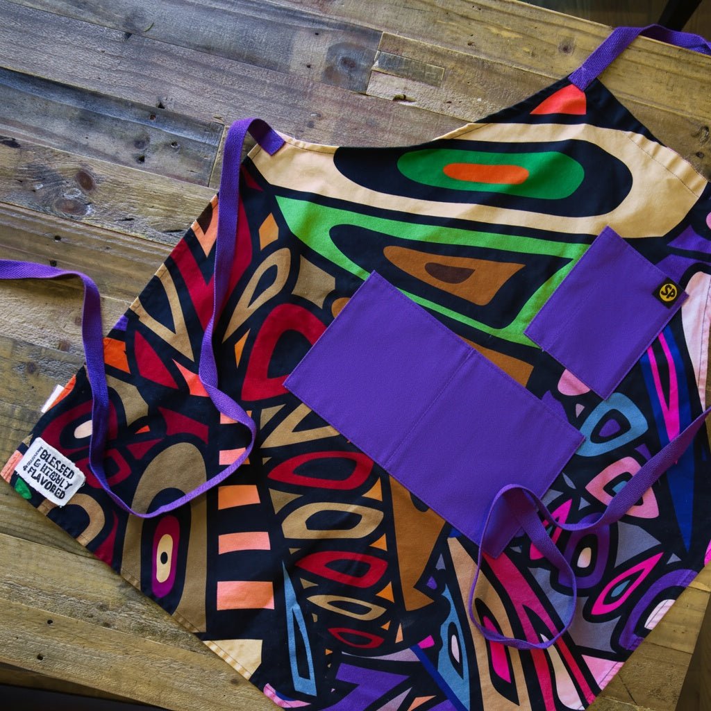 Aravella apron with a retro multicolor print and purple pockets, laid flat
