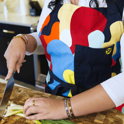 Beryl apron worn while preparing food, showing the black chest pocket