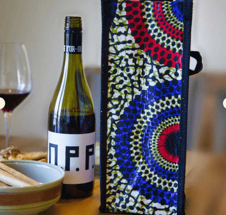 multicolor upcycled bottle bag beside wine and tableware