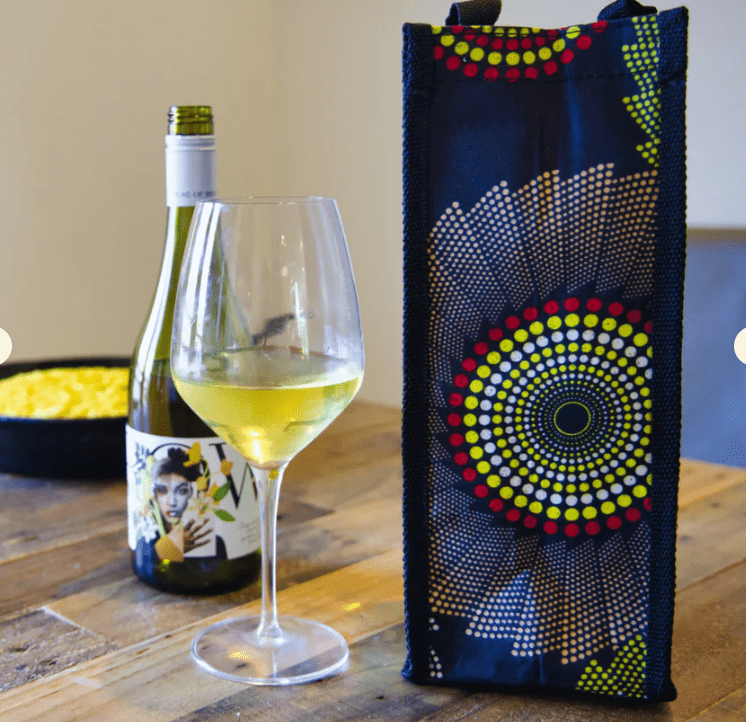 reusable dark circular-pattern wine bag beside a glass of white wine